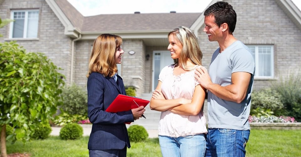 3 people talking near a house with a garden