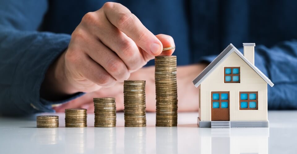 Coins near a model of a house